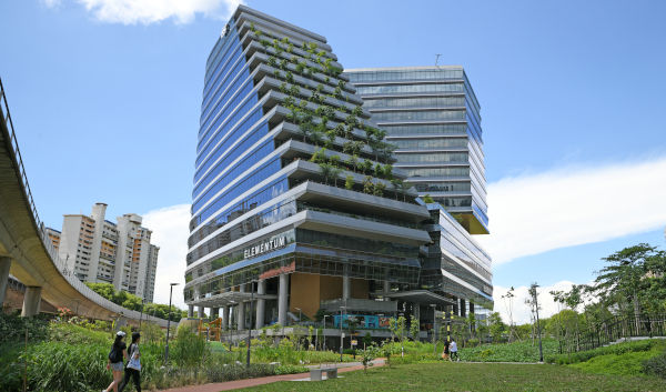 Modern building with tiered gardens, blue sky, and park. "Elementum" signage visible.